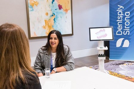 Dr Mahmood is having a good time and smiling with her patient in a dental chair