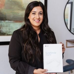 Sara the dentist is smiling with SureSmile certificate